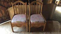 Pair of wicker and bamboo chairs side by side showing their overall structure and fabric cushions.