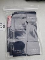 Clear sealed plastic bag with multiple Youngblood cosmetic products in black packets and boxes with white text.