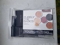Photo of Youngblood mineral cosmetics packaged in a clear plastic bag, showing boxed powders and makeup items for dark skin tones.