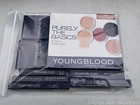 Youngblood Mineral Cosmetics makeup set packed in a clear resealable plastic bag showing Purely The Basics box, two compact containers, and three boxed lip products.