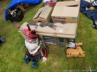 Photo shows 3-foot elf figure next to the boxed 7-foot NOMA lighted tree, a wire metal star and a wooden deer figure.