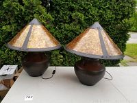 Front view of both matching lamps showing amber mica shades and dark metal urn-shaped bases