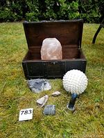 Overview of the lot showing salt stone, amethyst quartz, ore drilling sample, rough stones, spherical lamp, and wooden box on grass.