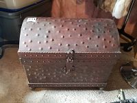 Front angled view of the heavy metal chest showing the riveted domed lid and latch.