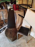 Photo showing leopard print high heel chair and adjacent black side table.