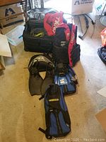 Full set of snorkel gear including two O'Neill life vests, two pairs of fins, masks, snorkels, and Tumi roller bag in a room setting.