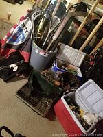 Photo of various outdoor and camping items grouped including coolers, sporting sticks and umbrellas