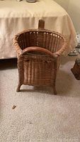 Front view of the antique woven grape picking basket showing its rectangular shape, woven construction, and single wooden handle.