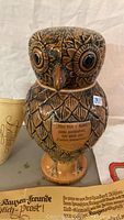 Owl-shaped beer vessel with visible German inscription plaque on chest