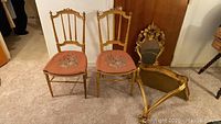 Two gilt wood side chairs and matching wall mirror grouped together