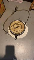 Full view of the vintage hanging scale with hook and attached metal frame capturing overall condition.