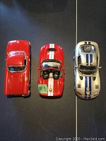 Top view of three diecast collector cars: red Viper, red Corvette with white racing stripe, silver Shelby with blue racing stripes.