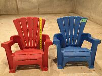 Photo of two mini-sized plastic Muskoka chairs, one red and one blue, shown side by side on a concrete floor, with a measuring stick beside the red chair indicating height.