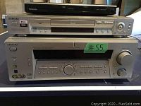 Photo showing Sony DVD player on top of Sony digital audio/video control receiver with green labeled #55 sticker, and Toshiba DVD player placed above them.