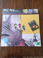 Canvas memo board in original packaging showing Eiffel Tower and street lamp photo design, with labels indicating size 20x20 inches and inclusion of 2 magnets.