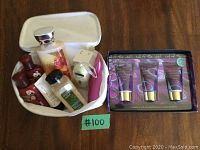 Photo showing a white Clarins bag filled with assorted bath and body products including bottles and tubes, plus a boxed set of Call of the Wild hand cream, wash, and body lotion.