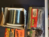 Photo of large spool of fishing line in box and pack of Zoom soft baits