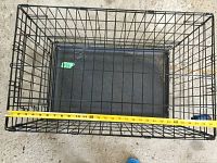 Photo showing the length measurement of the wire animal cage with plastic tray inside, measuring about 26 inches.