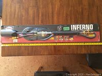 Full view of Harris Inferno propane torch in original packaging with hose coiled.