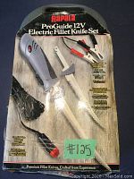 Front of product box for Rapala ProGuide 12V Electric Fillet Knife Set showing the knife, blades, power adapter, and features.