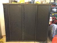 Close front-facing view of black foldable tonneau cover showing textured surface and metallic hinges.