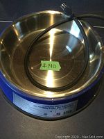 Stainless steel heated pet bowl, showing the inside and the attached power cord.