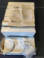 Stacked white boxes with several pendant lights on top with instruction sheet visible, showing the Gallery brand and product information.