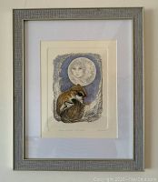 Framed hand colored etching artwork showing the print in its frame hung on a wall.