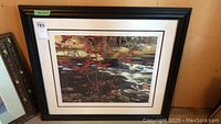 Full front view of framed print with black frame and white matting showing flow of river and red maple tree.