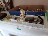 Wide view of the lot showing watches, jewelry in box and ceramic figurine
