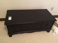 Front and top view of black painted cedar chest showing carved edge details and front drawers with metal pulls.