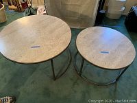 Both nesting coffee tables showing travertine tops and metal bases