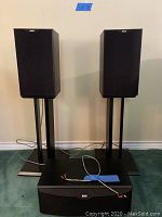 Two DM601 bookshelf speakers on stands with CC6 center speaker in front