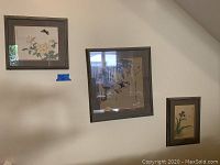 Three framed Asian floral and bird art prints mounted on a wall