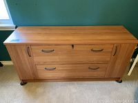 Front view of wood credenza file cabinet showing two drawers and two side cabinets with handles