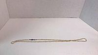 Full length of the pearl necklace laid out showcasing the entire strand and clasp.