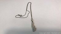 Close-up photo of 925 stamped silver cat pendant hanging on chain