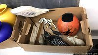 Box with wooden carvings including duck decoy, loon figurine, small zebra, pig carving, and gourd bowl with painted designs