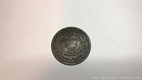 Photo of Nova Scotia coin from 1861 showing crown and wreath design and date.