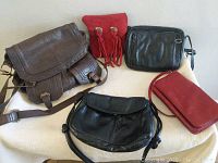 Five leather purses on a white cloth background showing design and colors