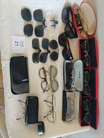 Top-down view of the full lot showing glasses, clip-ons, and cases arranged on a light surface.