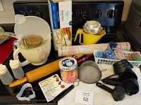 Overview of baking utensils and kitchen accessories including measuring cups, rolling pin, mixing bowls, cutters and slicers