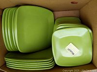 Top-down view of stacked large and smaller avocado green melmac square plates, showing quantity and color.