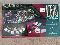 Box showing the Vegas Casino Trio game set with Blackjack '21, Craps, Roulette and game components.