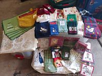Wide view of assorted holiday linens including towels, placemats, and aprons arranged for display.