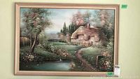 Frontal view of the framed painting showing the full pastoral scene including cottage, trees, and stream.
