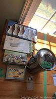 Photo showing all items: packaged white appetizer spoons, asparagus cooker, eggcups, and egg spoons boxes.