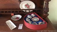 Photo shows 6 hand-painted small cups and saucers in heart-shaped red box, octagonal rose pattern bowl, and rectangular clover pattern dish.