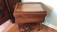 Front view of wooden tea trolley with serving tray in place