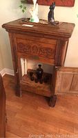 Full front view of oak icebox cabinet with carved panels and top items